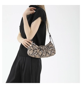 Detail of snake print shoulder bag with vintage metal buckle and adjustable strap