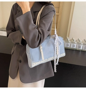 Detail of light blue PU handbag with floral patchwork, white handle and lace bow accessory