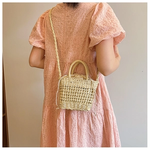 Detail of woven straw handbag featuring delicate texture and drawstring closure lining