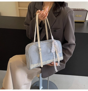 Detail view of light blue rectangular handbag with floral patchwork and lace bow ornament