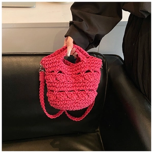 Detail of hand-woven rose red knit crossbody bag with wavy texture and silver metal hardware