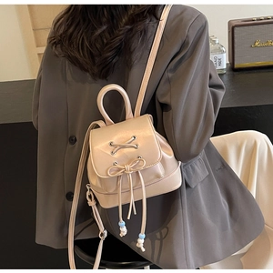 Detailed back view of a mini beige PU leather backpack with bow-knot and lacing details