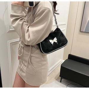 Détail du sac bandoulière en cuir PU noir avec papillon blanc et surpiqûres blanches