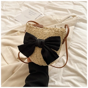 Sac seau en paille tissée avec grand nœud en tissu noir et bandoulière en cuir marron