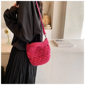 Detail of magenta crochet handbag showing textured knit pattern and silver metal hardware