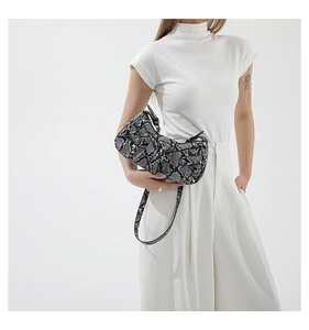 Detail view of the black and white snakeskin pattern and asymmetric saddle bag shape