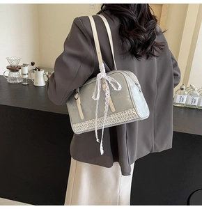 Close-up of a light grey PU shoulder bag with floral patchwork and lace bow decoration