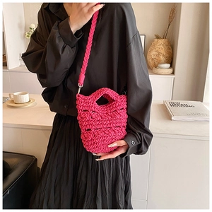 Close-up of rose red hand-knitted crossbody bag with textured hollow weave design