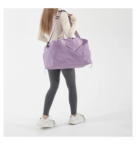 Detailed view of purple nylon sports bag showing spacious side pocket and thick strap