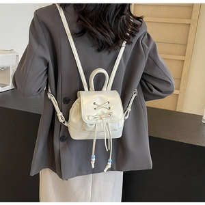 Detail of white PU leather mini backpack with drawstring and bow knot decoration