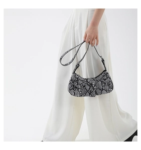 Close-up of snake skin texture PU leather shoulder bag with adjustable metal buckle