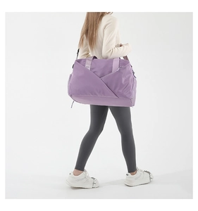 Detailed view of purple large capacity nylon sports bag worn by a model in studio