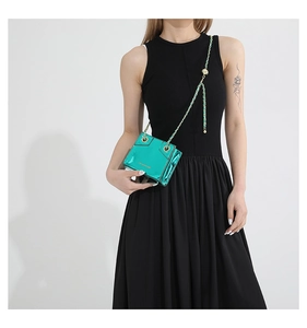 Close-up of bright green mini square crossbody bag with metallic mirror finish and gold chain