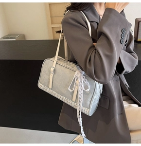 Detail of gray blue PU leather shoulder bag with floral trim and white lace ribbon decoration