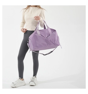 Detail view of purple waterproof nylon gym bag with side shoe compartment and shoulder strap