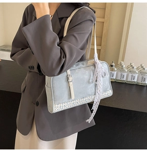 Detail of gray PU handbag featuring floral trim and a white lace decorative ribbon strap