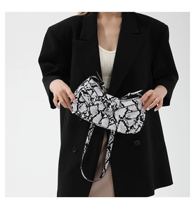 Detailed view of black and white snakeskin PU leather shoulder bag with silver zippers