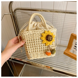 Handmade woven straw handbag with floral sunflower design and drawstring inner bag