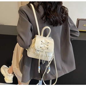 Minimalist white PU leather mini backpack with stylish bow detail shown on a model