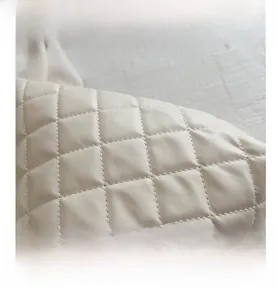 Gros plan sur cuir PU matelassé beige avec surpiqûres en losange sur le sac à main