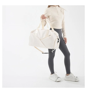 Close-up of the large cream travel bag featuring reinforced handles and side zipper details