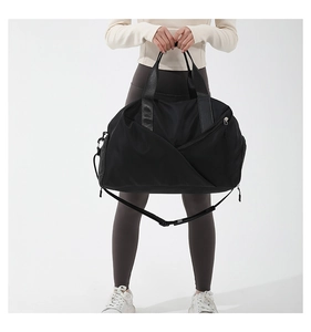 Detailed shot of durable black nylon travel bag featuring adjustable shoulder strap and handles