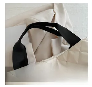 Détail du sac à main en similicuir matelassé beige avec poignées tissées noires chic