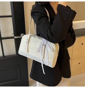 Close-up of cream PU leather handbag featuring light blue floral embroidery and lace bow