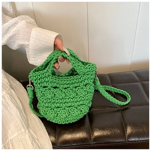 Detail of green handmade knitted crossbody bag showing chunky woven rope texture and strap