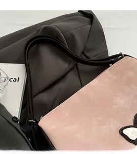 Close-up of pink matte PU handbag featuring white butterfly detail and brown strap