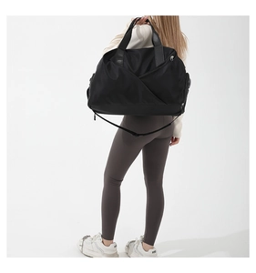 Rear view of a model wearing the large black nylon crossbody travel bag with shoulder strap