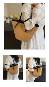 Detail of large woven straw tote with black leather handles and trim for summer style