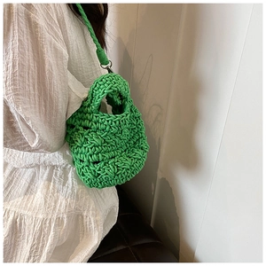 Detail of hand-woven bright green knit bag showing thick texture and woven strap