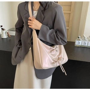 Detail of light apricot PU leather handbag featuring decorative bow and drawstring accents