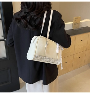Detail view of cream PU leather crossbody bag featuring floral patchwork and lace bow accents