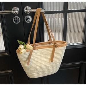 Detail of hand-woven beige tote bag with premium brown faux leather handles