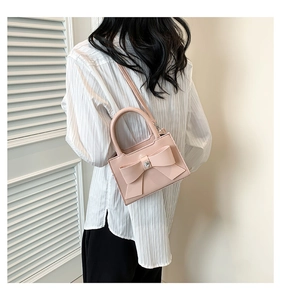 Détail du sac bandoulière rose en PU avec un grand nœud et boucle en métal en cœur