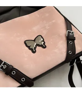 Close-up of pink faux leather crossbody bag featuring a silver fluid butterfly metal logo
