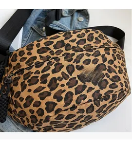 Close-up of leopard print crossbody bag with black adjustable strap and zipper detail