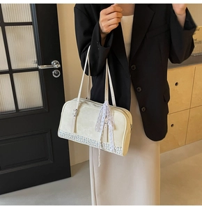 Detail view of cream PU leather handbag with blue floral base and lace bow charm