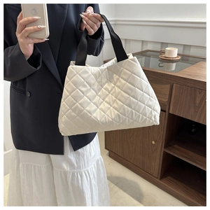 Détail du sac cabas matelassé beige crème avec larges bandoulières noires et tissu doux