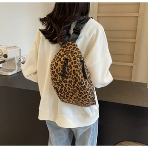 Detail of leopard print crossbody bag featuring adjustable strap and dual zipper closure