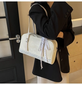 Close-up of cream PU leather handbag with floral patchwork and delicate lace bow detail