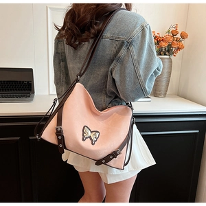 Detail of pink PU leather Hobo bag with shiny butterfly logo and adjustable brown strap