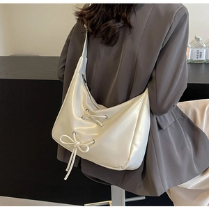 Detailed back view of a white hobo bag with ribbon bows and silver metal eyelets
