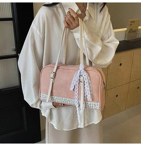 Close-up of pink PU leather handbag with vintage floral bottom and white lace ribbon