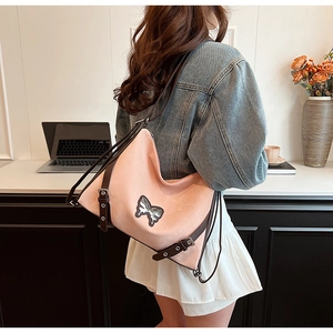 Detailed shot of pink PU leather shoulder bag with vintage butterfly embroidery and brown strap