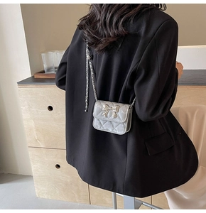 Rear view of a silver mini crossbody bag with a 3D bow and metal chain strap