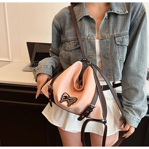 Detail of pink PU leather hobo bag with brown butterfly patch and metallic buckles