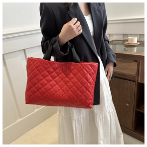 Détail du sac cabas rouge en similicuir matelassé avec sangles noires et losanges